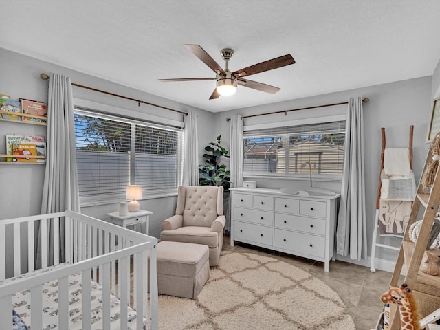 bedroom with a ceiling fan and a crib