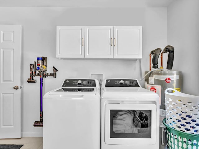 laundry area featuring washing machine and dryer, water heater, and cabinet space