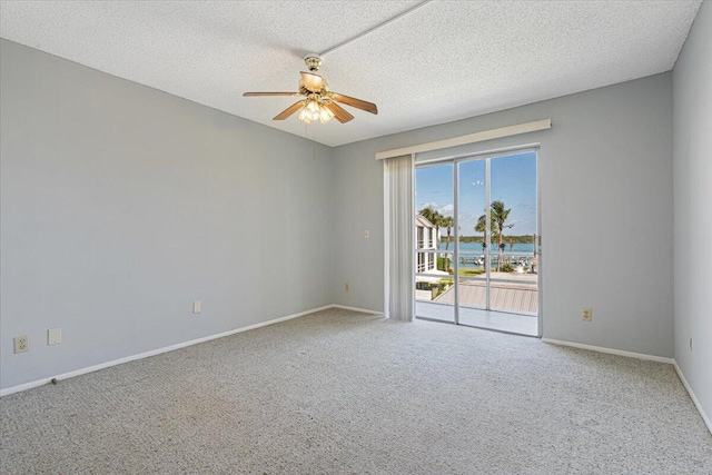 spare room with baseboards, ceiling fan, carpet, and a textured ceiling