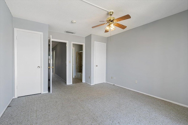 unfurnished bedroom with baseboards, ensuite bathroom, carpet flooring, and visible vents