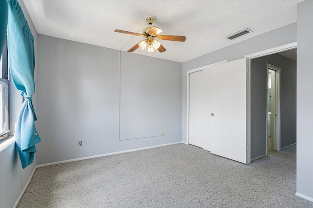 unfurnished room with a ceiling fan, baseboards, visible vents, and a textured ceiling