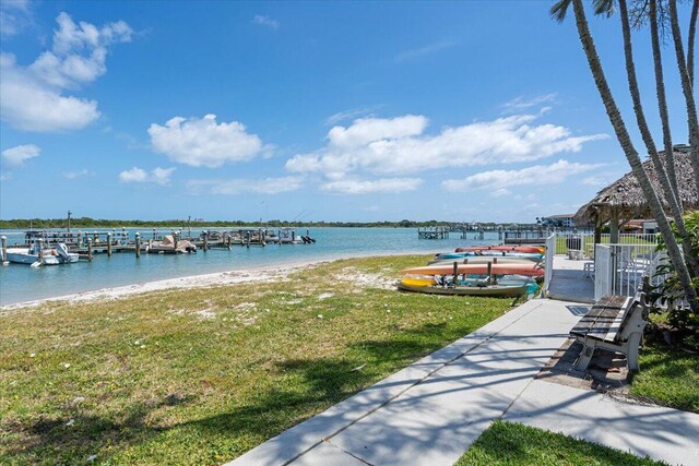 dock area with a water view and a yard