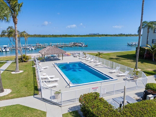 pool featuring a yard, a water view, a gazebo, and fence