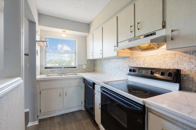 kitchen with a sink, light countertops, black appliances, and under cabinet range hood