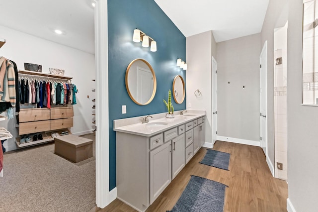 9891 SW Legacy Dr, Stuart, FL 34997 - bathroom featuring double vanity, wood finished floors, and a spacious closet
