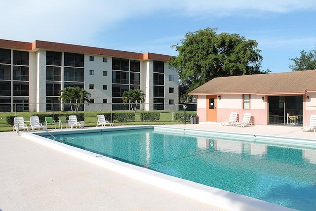 community pool featuring fence and a patio