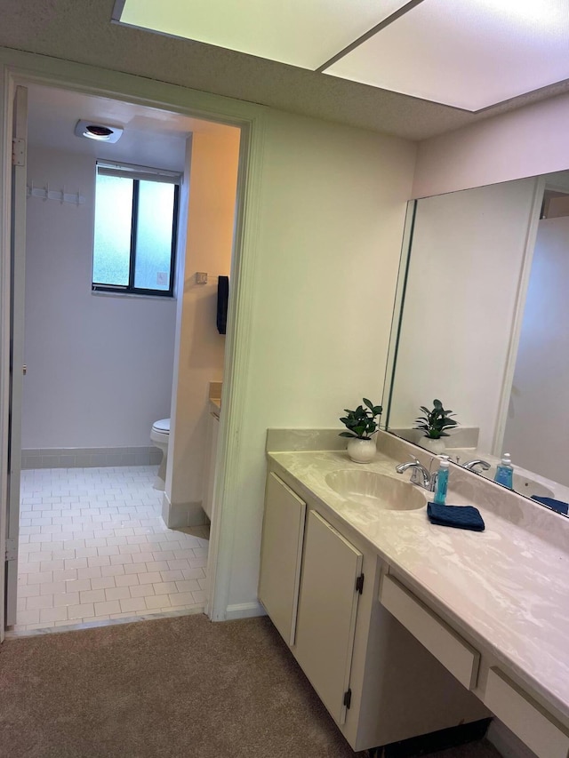 bathroom with vanity, baseboards, toilet, and tile patterned floors