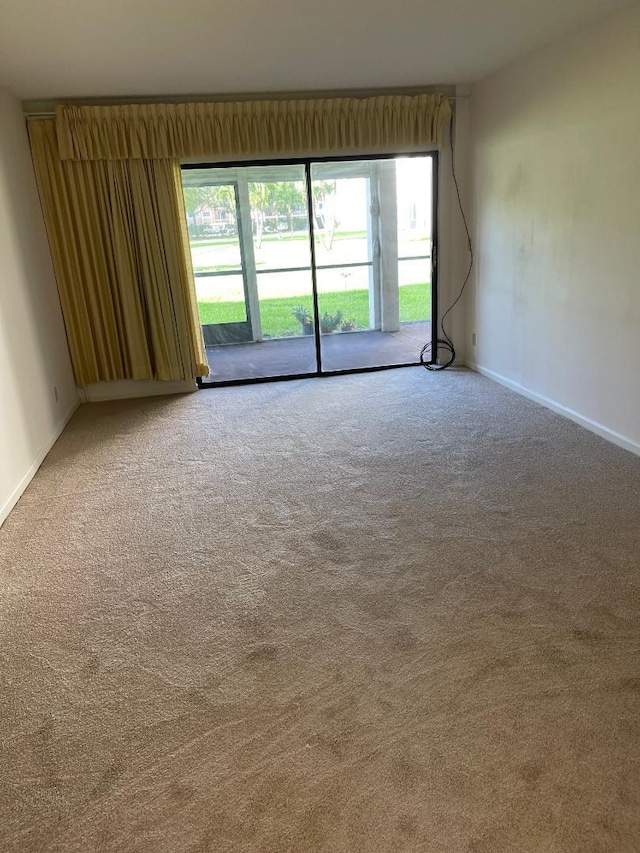 empty room with carpet and baseboards