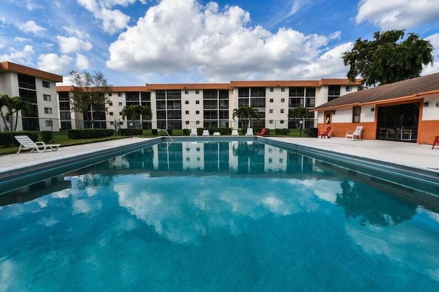 community pool featuring fence and a patio area