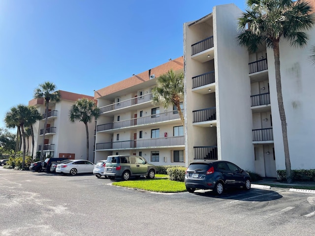 view of apartment building / complex with uncovered parking