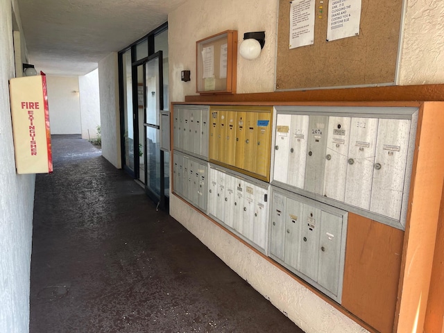 hall featuring mail area and concrete flooring