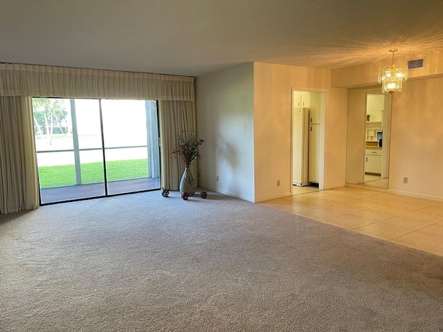 spare room featuring a chandelier, light carpet, baseboards, and light tile patterned flooring