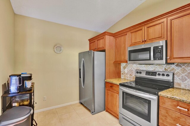 124 Mayfair Ln, Boynton Beach, FL 33426 - kitchen with appliances with stainless steel finishes, light stone counters, backsplash, brown cabinets, and lofted ceiling
