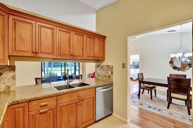 124 Mayfair Ln, Boynton Beach, FL 33426 - kitchen featuring stainless steel dishwasher, a chandelier, brown cabinets, and tasteful backsplash