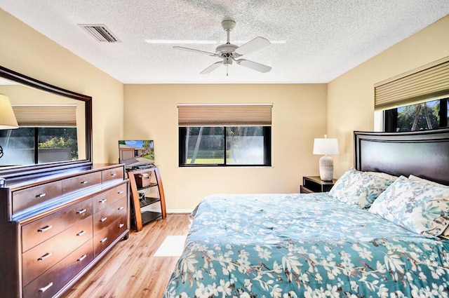124 Mayfair Ln, Boynton Beach, FL 33426 - bedroom with multiple windows, light wood-style floors, ceiling fan, and a textured ceiling