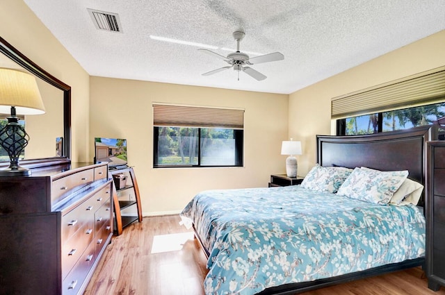 124 Mayfair Ln, Boynton Beach, FL 33426 - bedroom with wood finished floors, multiple windows, a ceiling fan, and a textured ceiling