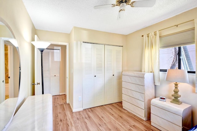 124 Mayfair Ln, Boynton Beach, FL 33426 - bedroom with arched walkways, light wood finished floors, a closet, a ceiling fan, and a textured ceiling