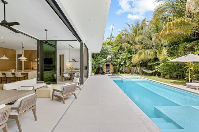 view of swimming pool with fence, a patio area, ceiling fan, and a fenced in pool