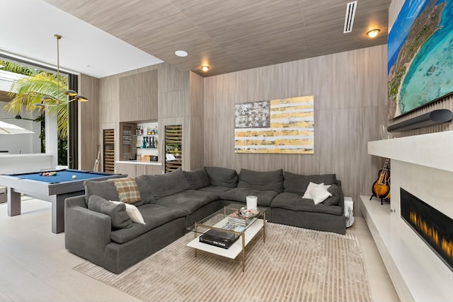 living room with a lit fireplace and pool table