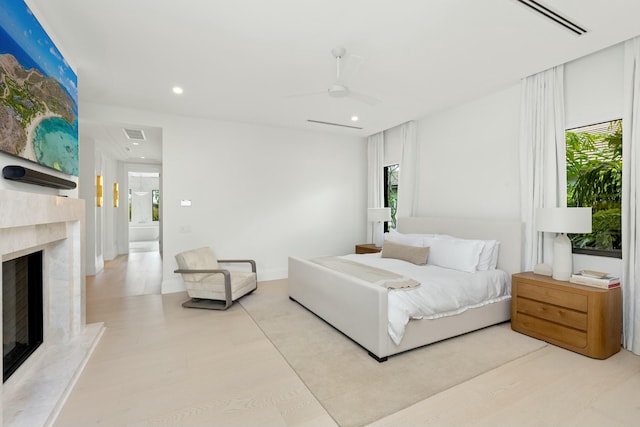 bedroom with recessed lighting, wood finished floors, a premium fireplace, visible vents, and a ceiling fan