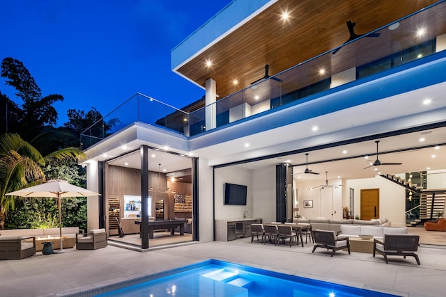rear view of property with an outdoor living space, outdoor dining area, a balcony, a patio area, and a ceiling fan