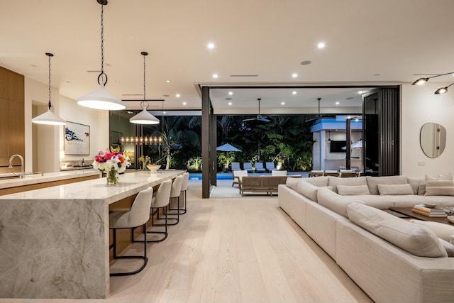 living area with light wood-type flooring, expansive windows, and recessed lighting