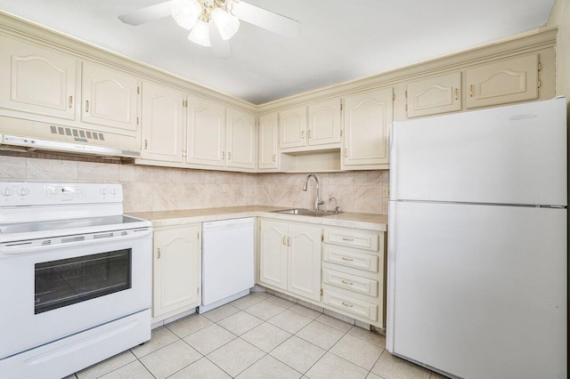 kitchen featuring under cabinet range hood, white appliances, cream cabinets, and a sink