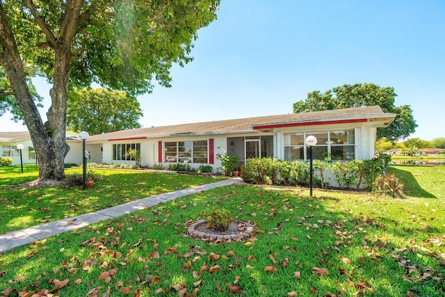 ranch-style house featuring a front yard and stucco siding