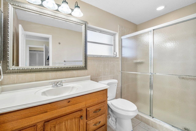 bathroom with toilet, vanity, a stall shower, and tile patterned flooring