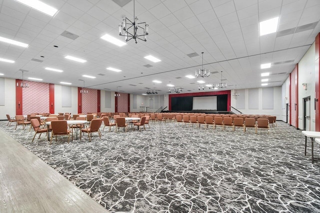 misc room featuring a chandelier and a paneled ceiling
