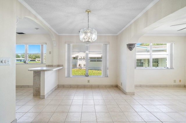 unfurnished dining area featuring crown molding, baseboards, arched walkways, and a notable chandelier