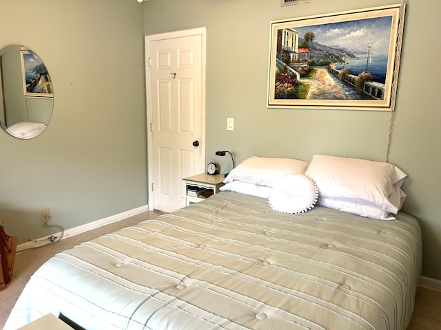 bedroom featuring light tile patterned floors and baseboards