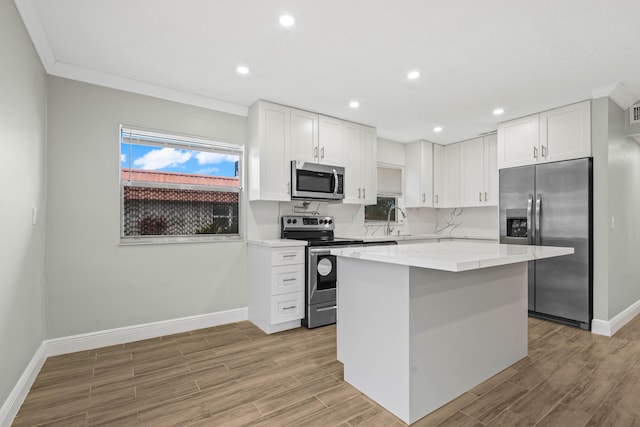 116 Seville D, Delray Beach, FL 33446 - kitchen with white cabinets, baseboards, appliances with stainless steel finishes, and a center island