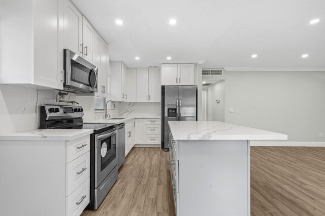 116 Seville D, Delray Beach, FL 33446 - kitchen with visible vents, a sink, stainless steel appliances, light wood-style flooring, and a kitchen island