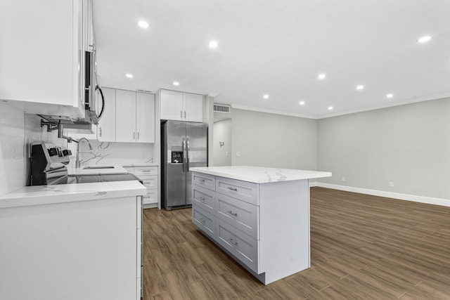 116 Seville D, Delray Beach, FL 33446 - kitchen featuring dark wood finished floors, visible vents, ornamental molding, and appliances with stainless steel finishes