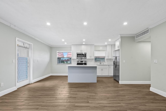 116 Seville D, Delray Beach, FL 33446 - kitchen with visible vents, white cabinets, baseboards, ornamental molding, and stainless steel appliances