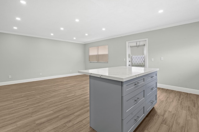116 Seville D, Delray Beach, FL 33446 - kitchen with light wood-type flooring, ornamental molding, gray cabinets, a center island, and baseboards