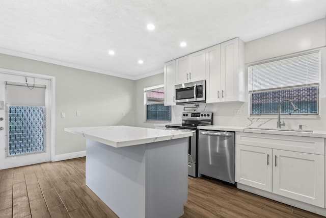 116 Seville D, Delray Beach, FL 33446 - kitchen with a sink, crown molding, recessed lighting, white cabinetry, and stainless steel appliances