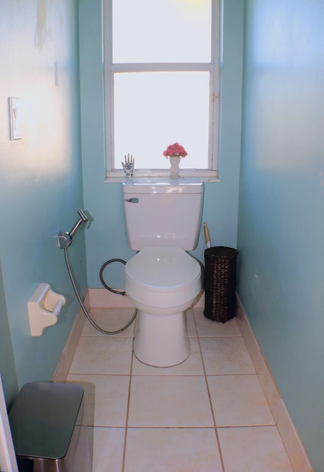 bathroom featuring toilet, tile patterned floors, and baseboards