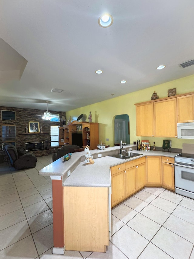 kitchen featuring arched walkways, white appliances, a sink, and open floor plan