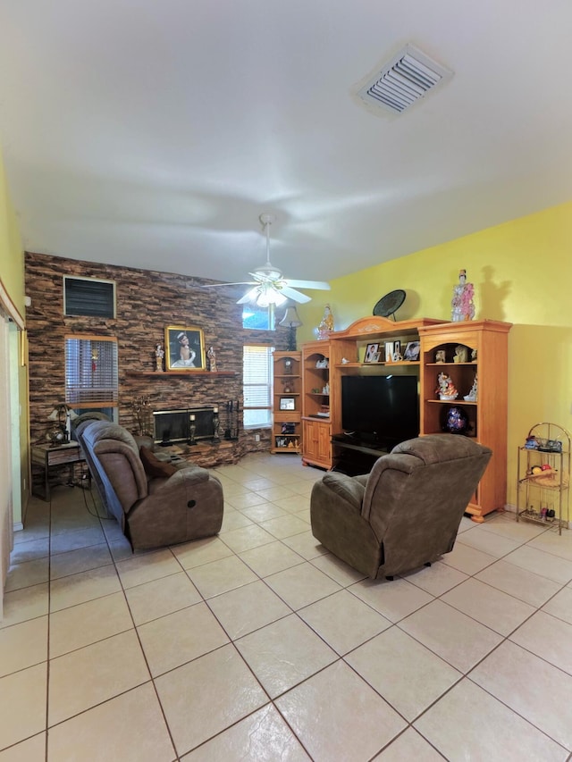 living room featuring a fireplace, light tile patterned floors, visible vents, and ceiling fan