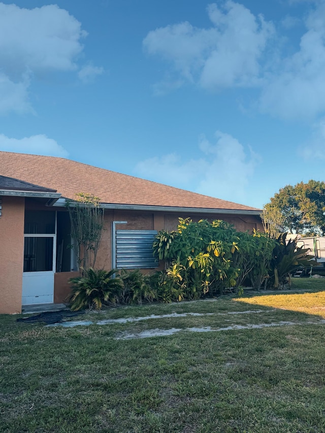 view of side of home with a yard
