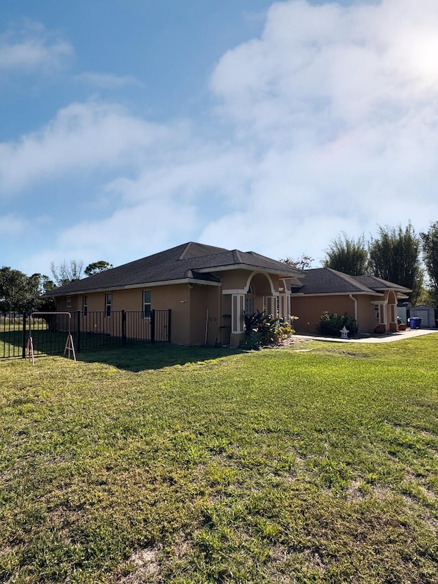 exterior space with a yard, stucco siding, and fence
