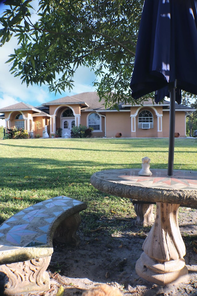 view of front of home with a front lawn and stucco siding