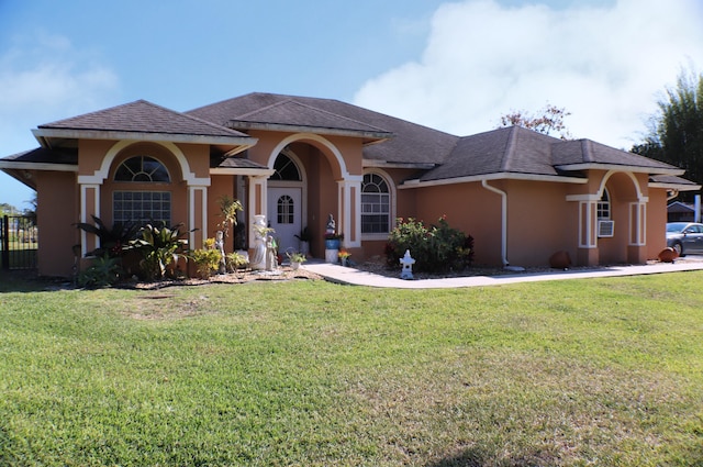 mediterranean / spanish-style house featuring a front yard and stucco siding