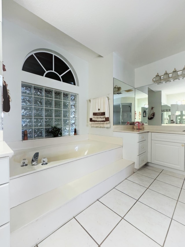 bathroom with tile patterned floors, vanity, and a bath