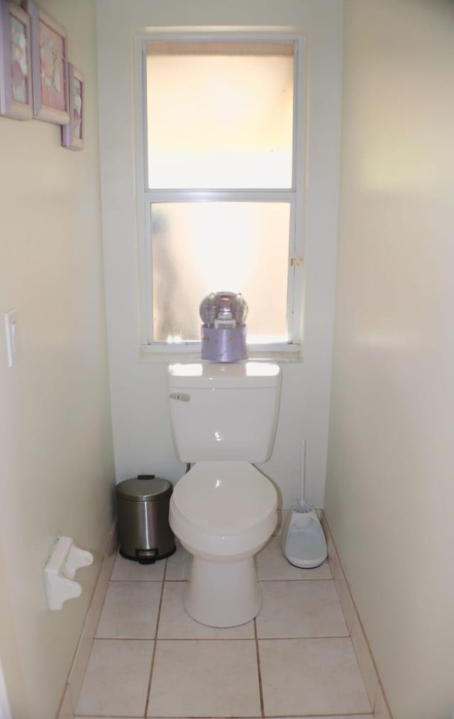 bathroom featuring toilet, baseboards, and tile patterned flooring