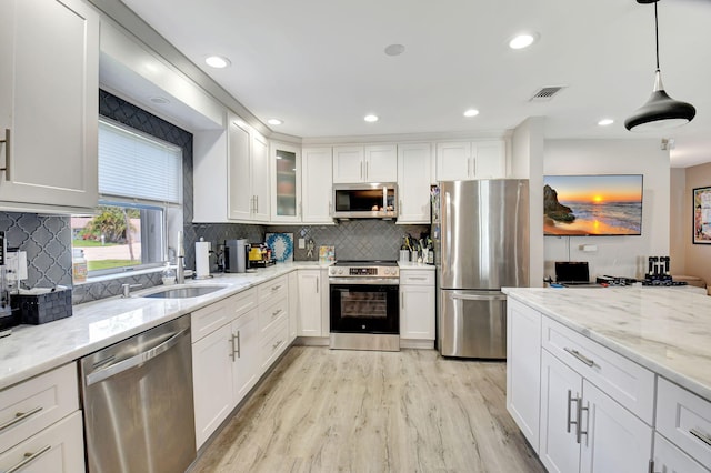 6122 Overland Pl, Delray Beach, FL 33484 - kitchen featuring light wood-style flooring, white cabinetry, visible vents, light stone counters, and stainless steel appliances