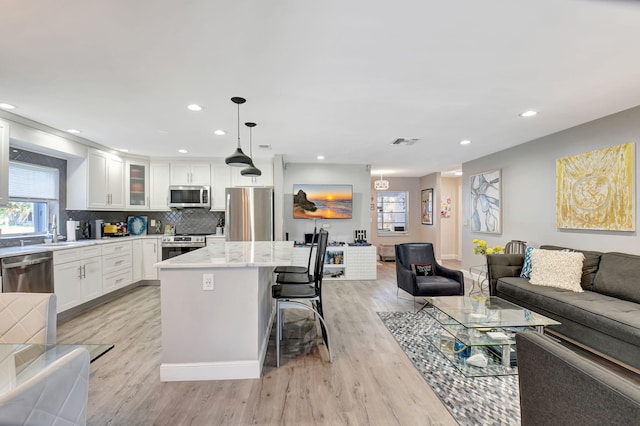 6122 Overland Pl, Delray Beach, FL 33484 - kitchen with open floor plan, a center island, appliances with stainless steel finishes, and light wood-type flooring