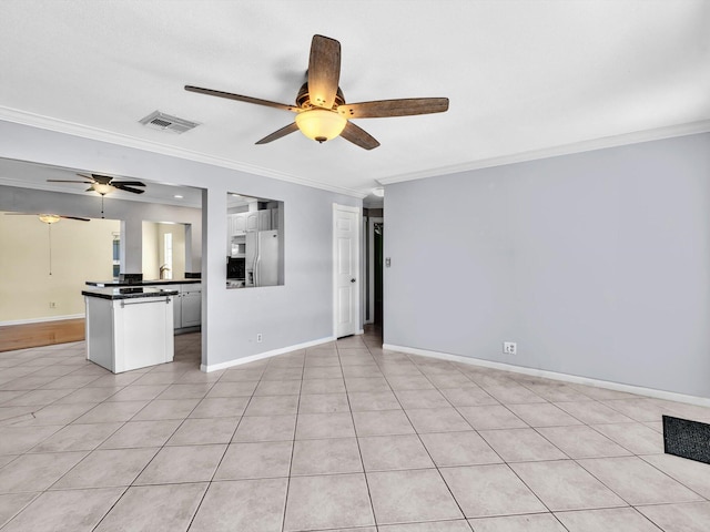 unfurnished living room with visible vents, ornamental molding, light tile patterned flooring, baseboards, and ceiling fan